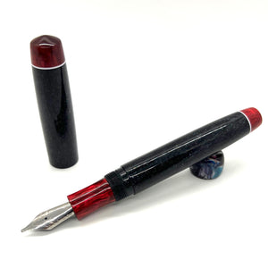 fountain pen, glittery black with red finials and section